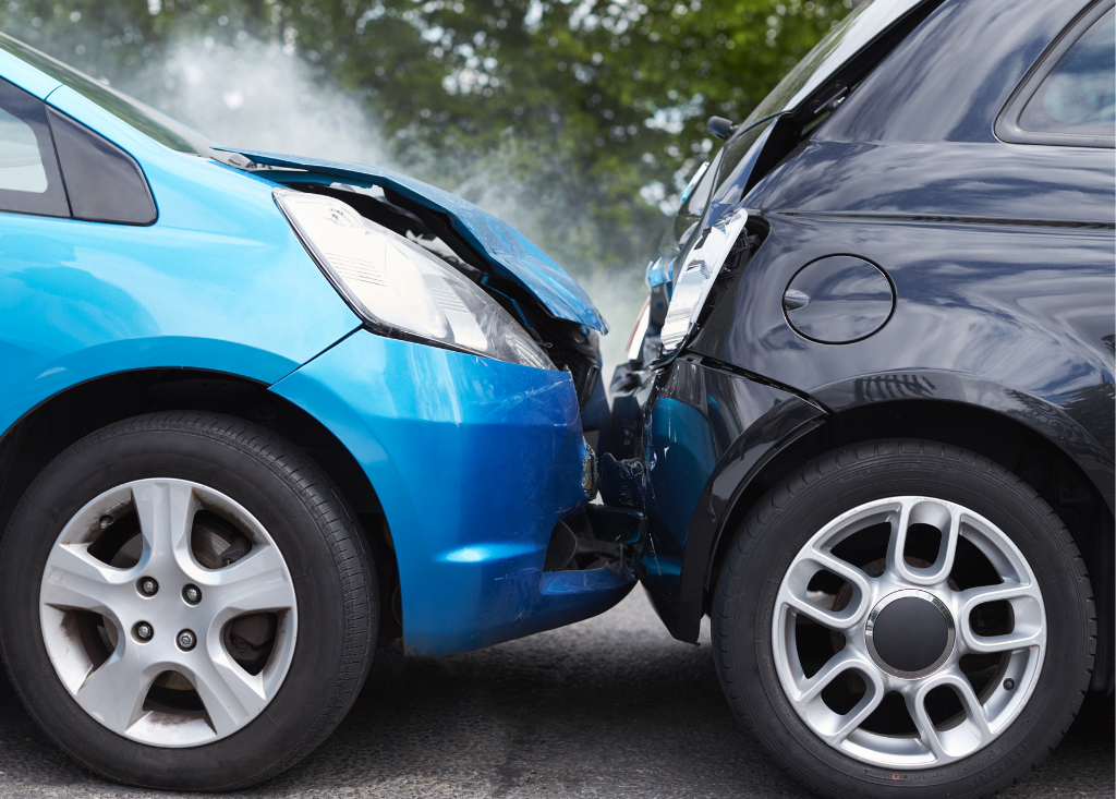 Zderzenie dwóch samochodów osobowych z uszkodzonymi maskami – symbolizujące sprawy o odszkodowanie.